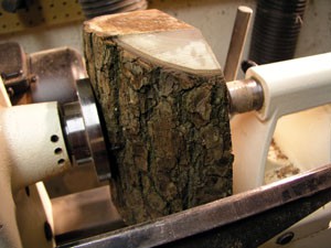 The Splintershop - Wood Art from the Lathe. The walnut log blank is mounted onto the lathe, using the tail stock to help support the blank.