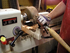 The Splintershop - Wood Art from the Lathe. A spinning walnut bowl blank gets the roughing gouge treatment to round out the blank.